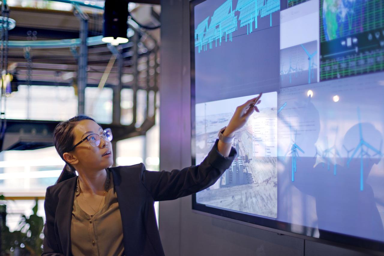 Woman pointing to data on digital screen