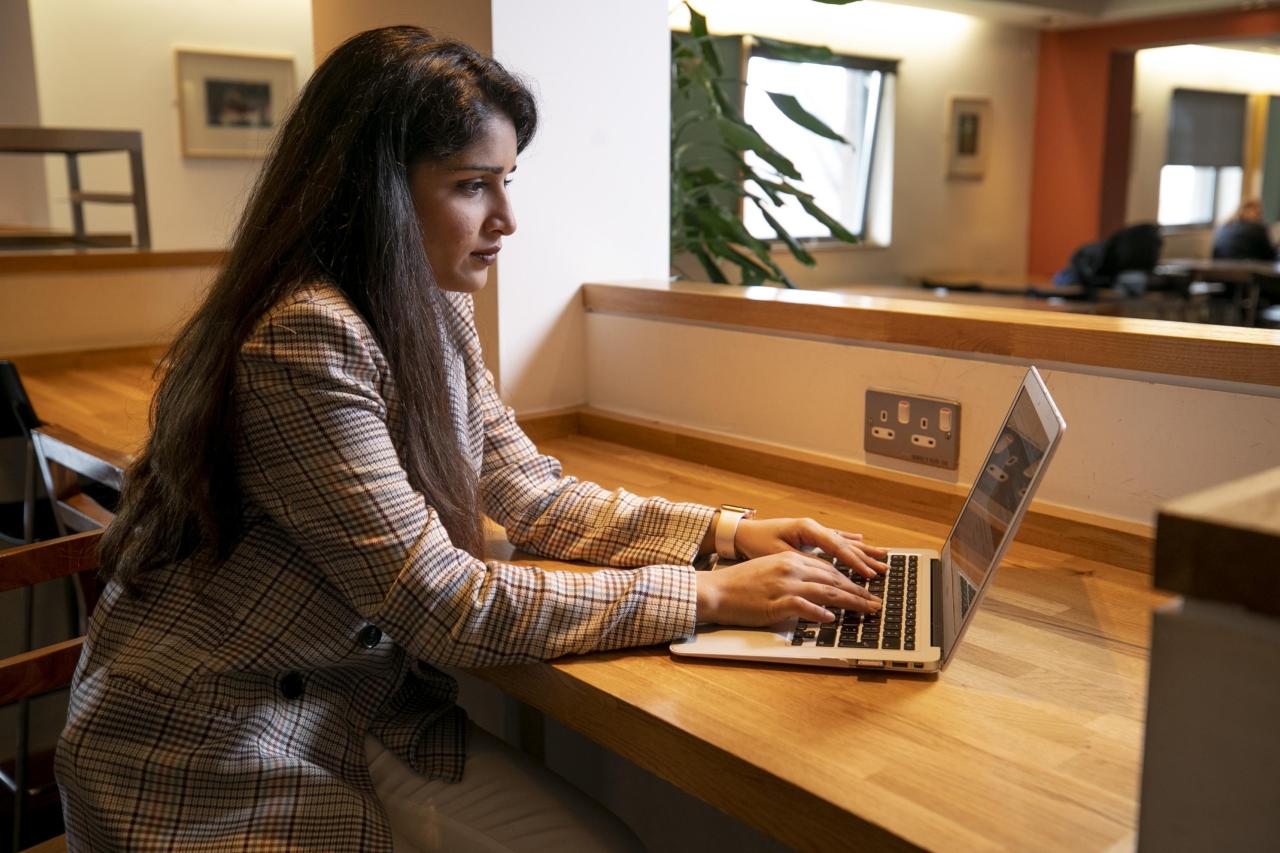 This image shows a female student working on a laptop