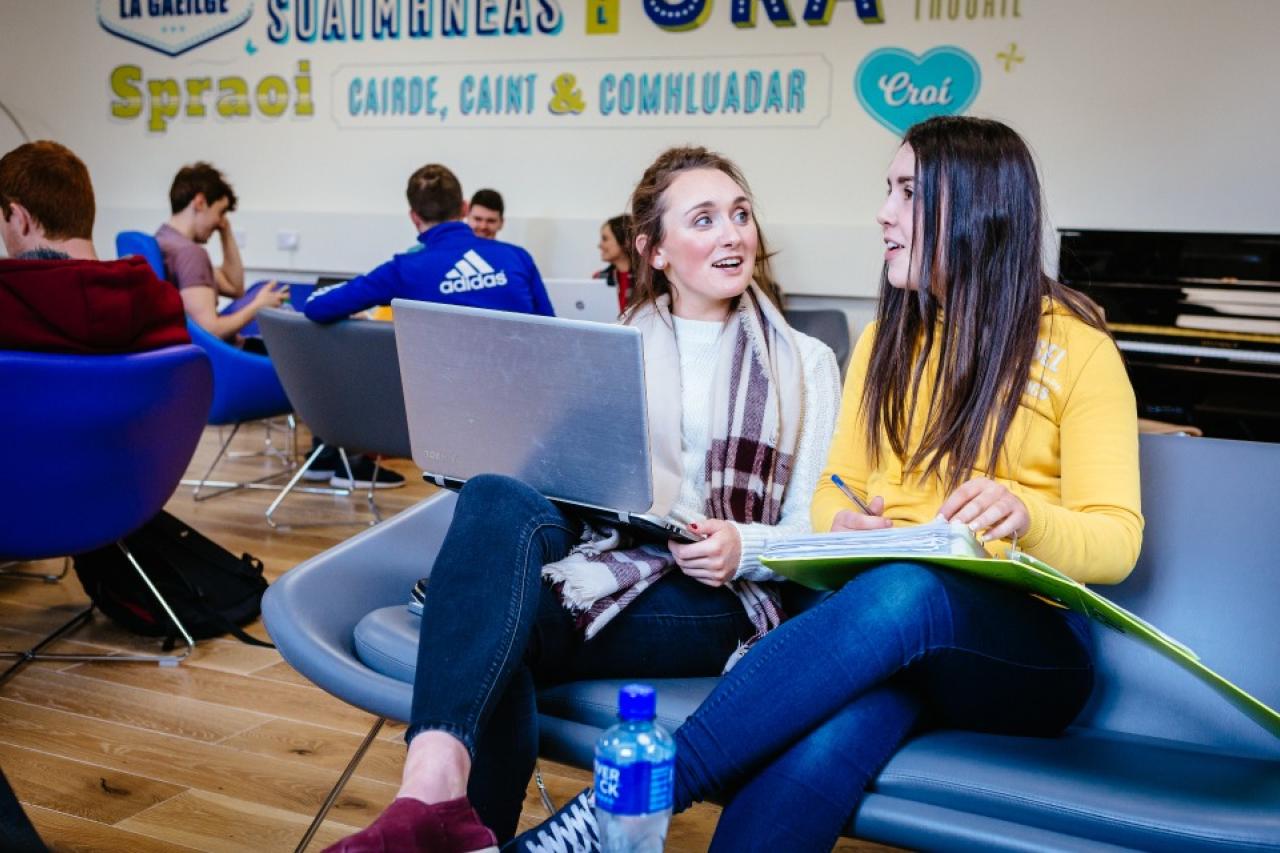 This photo shows two female students sitting and talking to each other