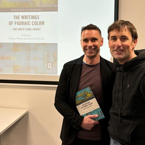 Shows authors holding edited collection of essays