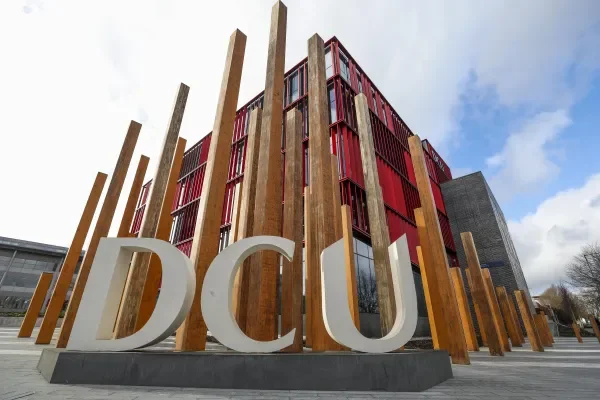 Shows DCU letters with Polaris building in the background