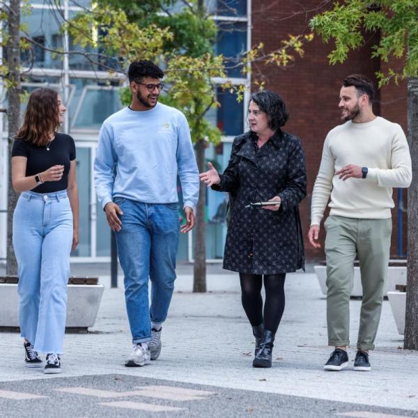 A group of students walking outside on campus.