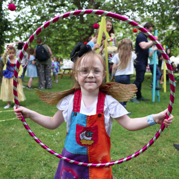 Shows young girl with hula hoop duirng Wild Neighbourhood event in DCU