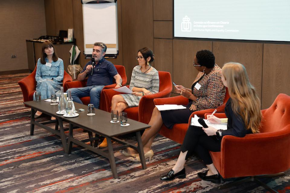 five panel members sit during panel discussion