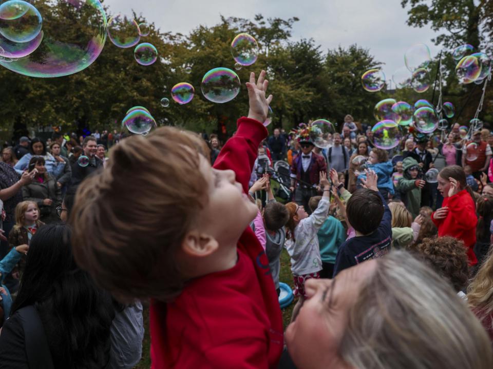 Community members gathered around bubbles in the air