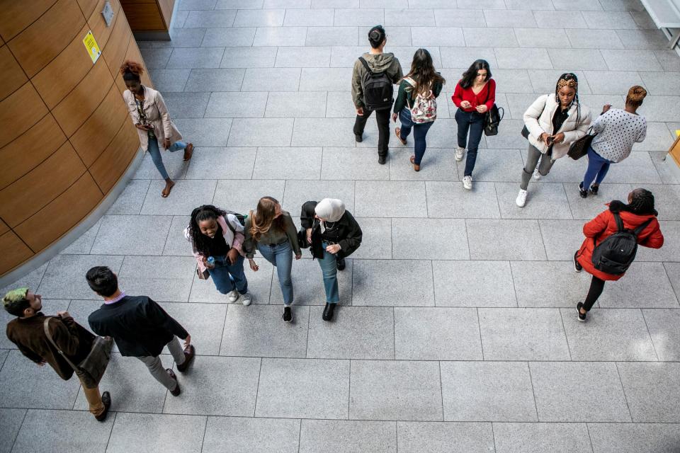 A top down photo of international students walking in small groups and chatting to each other.