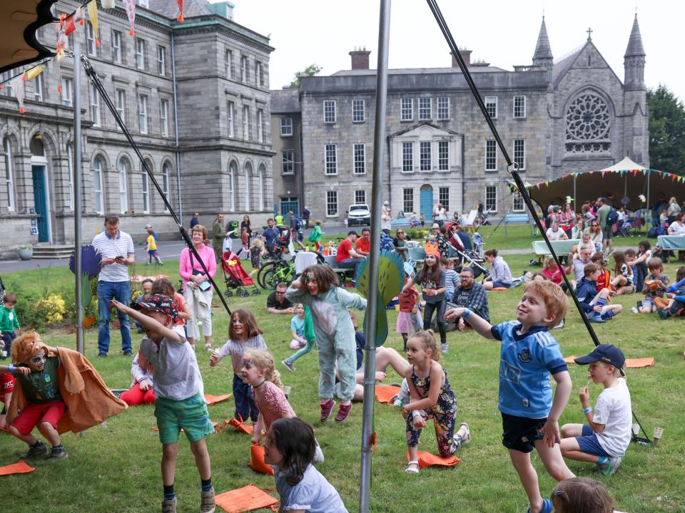 Children dancing in front of All Hallows buildings