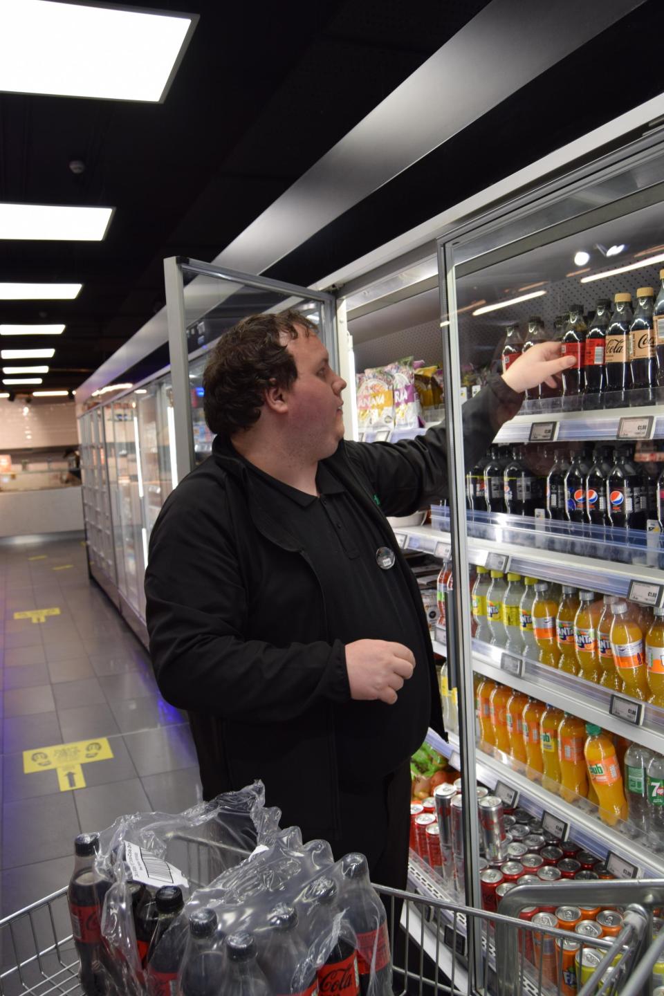 Bryan is stacking cold drinks in the DCU Londis store