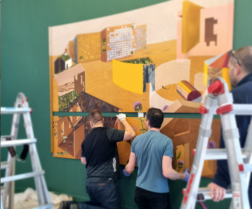 artwork being installed on the wall of DCU reception
