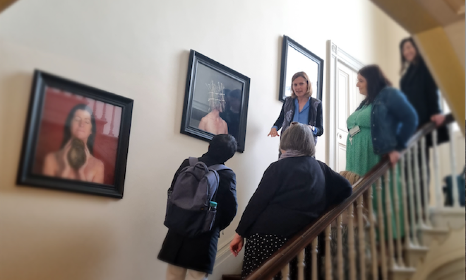 DCU staff looking at artwork on the walls of All Hallows campus