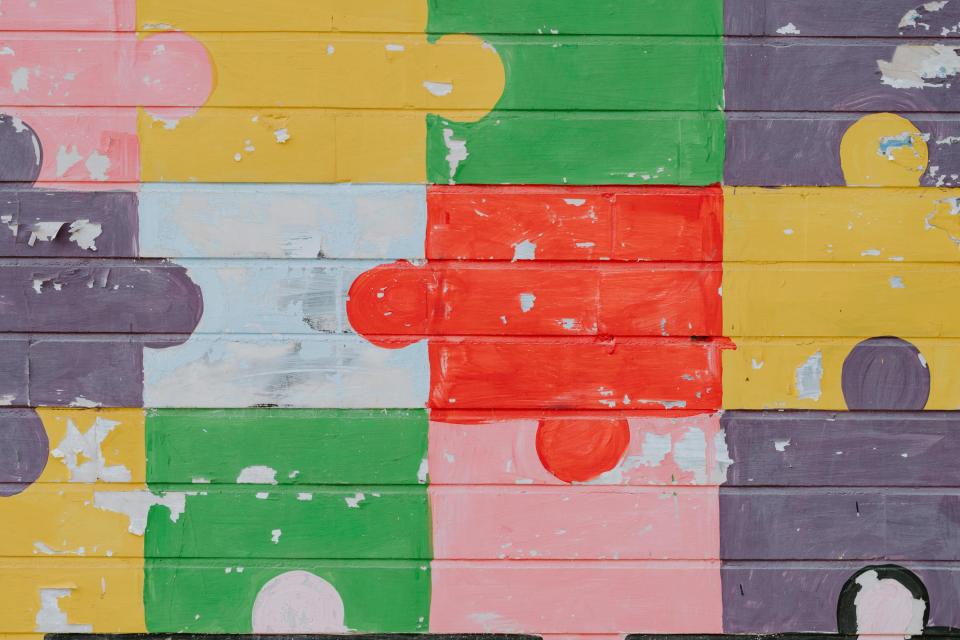 Colourful jigsaw pieces attached together.