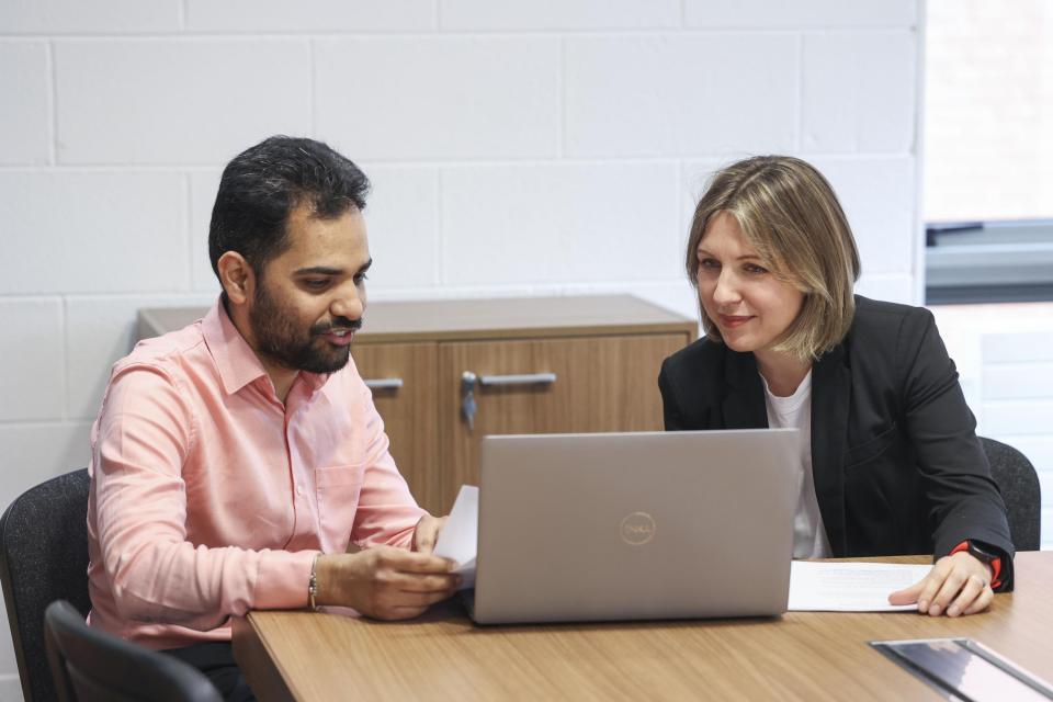 Two colleagues at laptop carrying out a PRD review