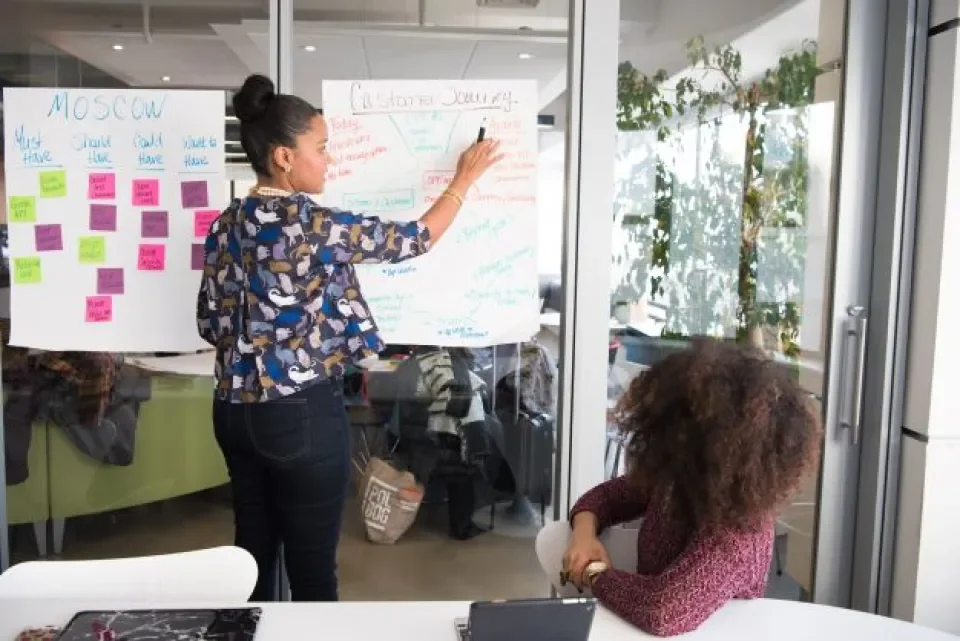 woman using postits on whiteboard