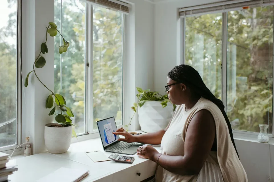 Woman sitting working at laptop in her own home