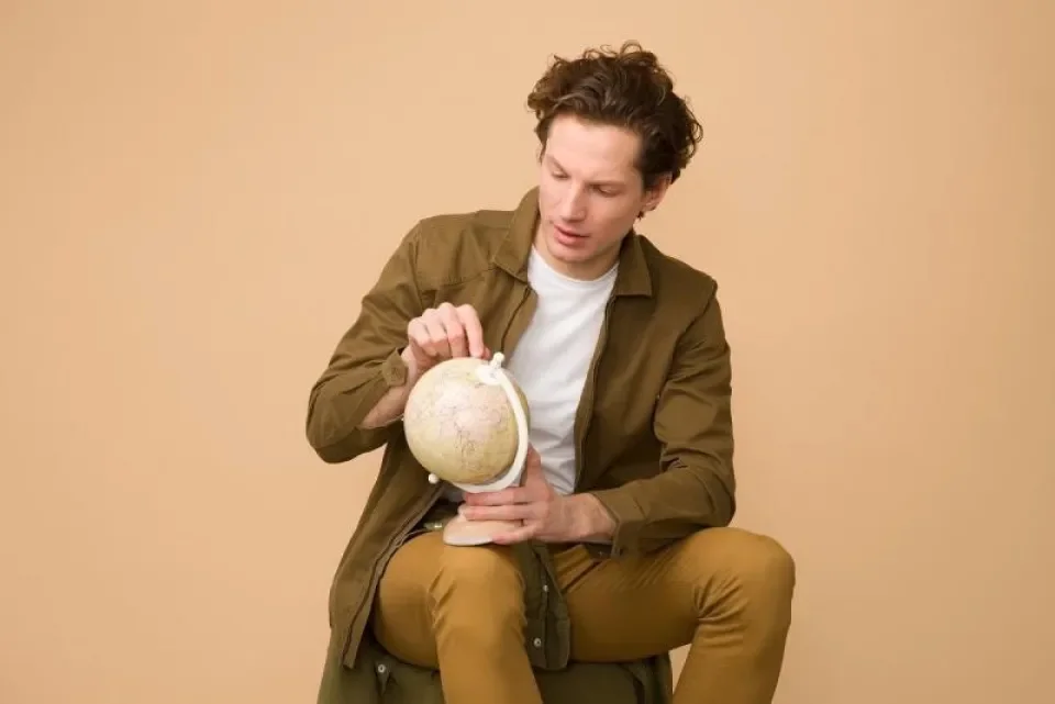 young man looking at a world globe