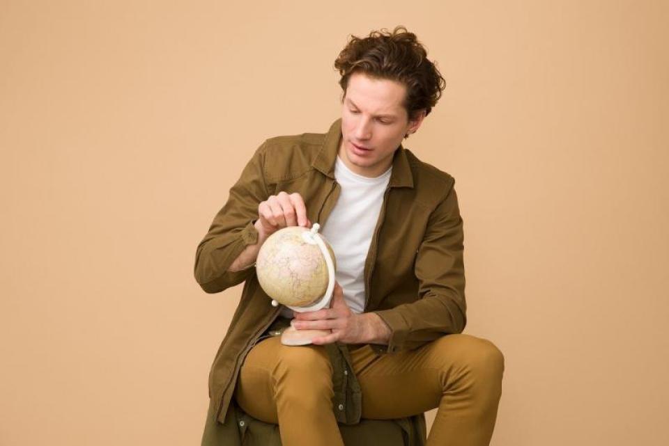 young man looking at a world globe