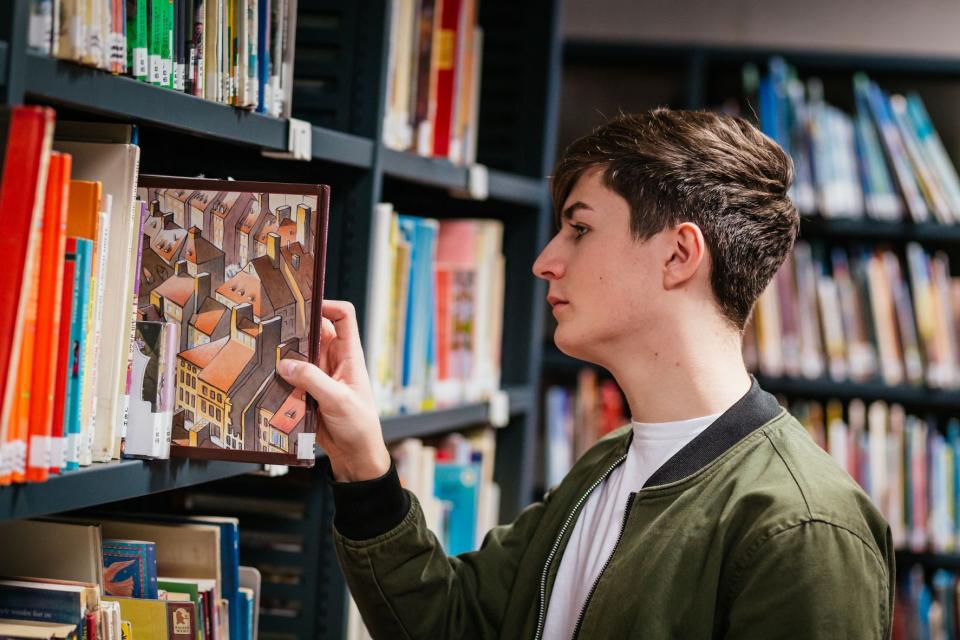 DCU students takes book from shelf