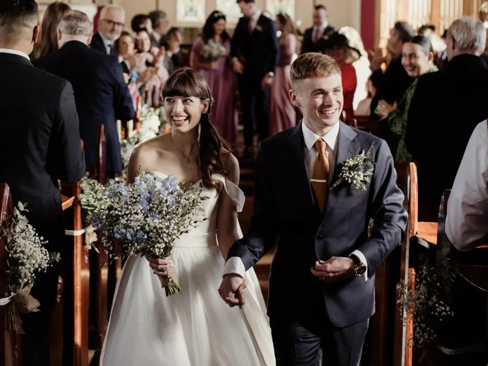 Image of Tom and Abigael walking down the aisle