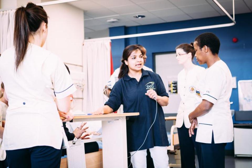 Student nurses being taught skills in a practice ward