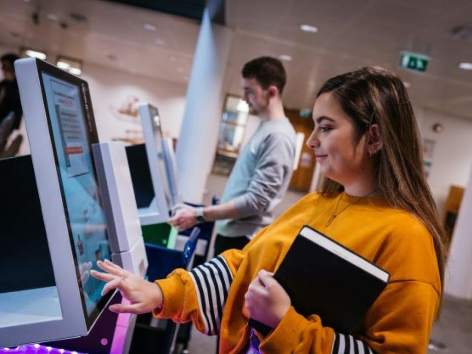 student borrowing material from self-service machine