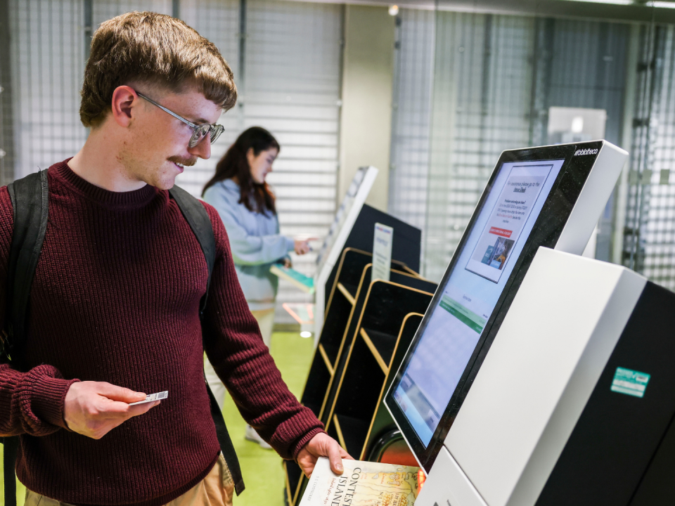 student borrowing material from self-service machine