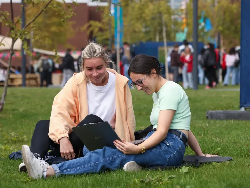 2 students sitting on the grass on Glasnevin campus
