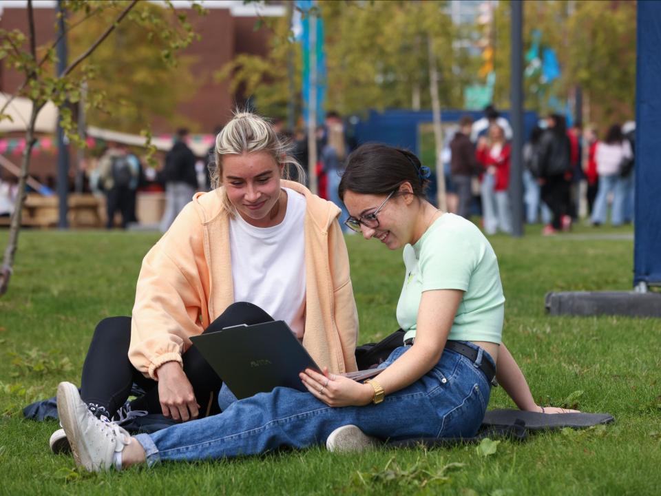 2 students sitting on the grass on Glasnevin campus