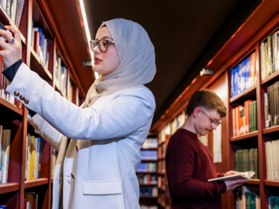 2 students browsing the book shelves in Woodlock Hall library