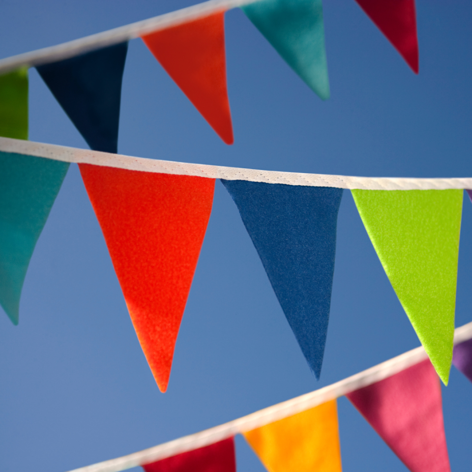 colourful, triangle-shaped bunting strewn across a bright blue sky