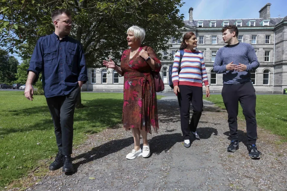 Four colleagues together walking on All Hallows campus