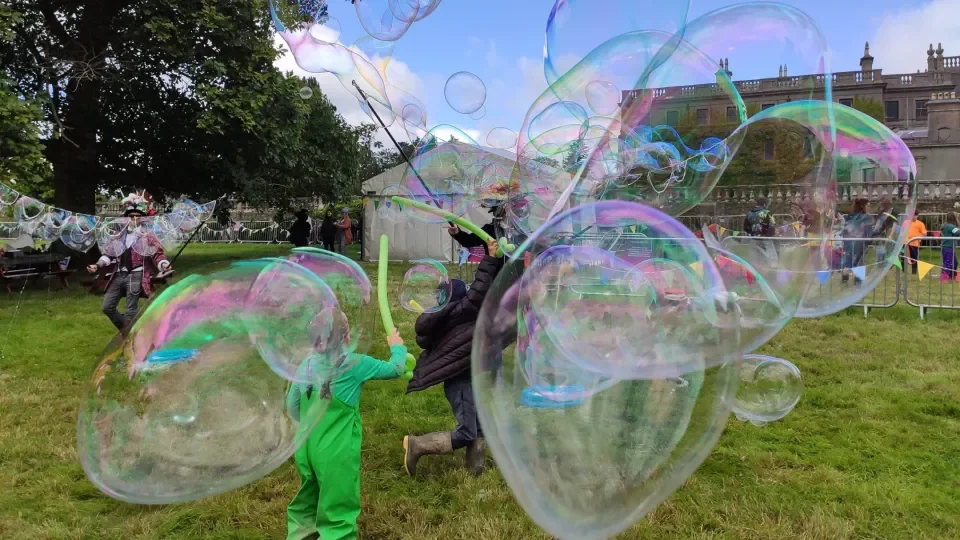 Giant Bubbles being created in a green field