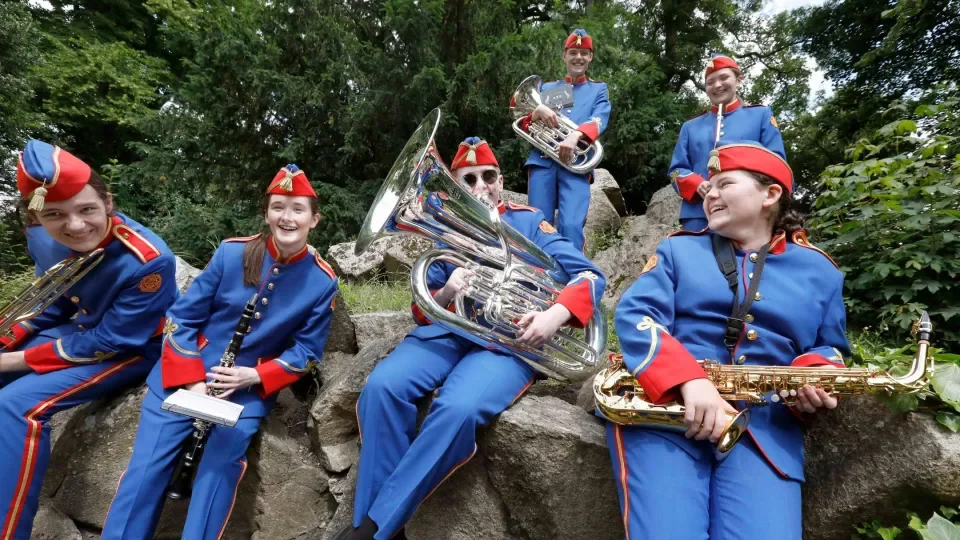 Young musicians holding their instruments laugh and joke