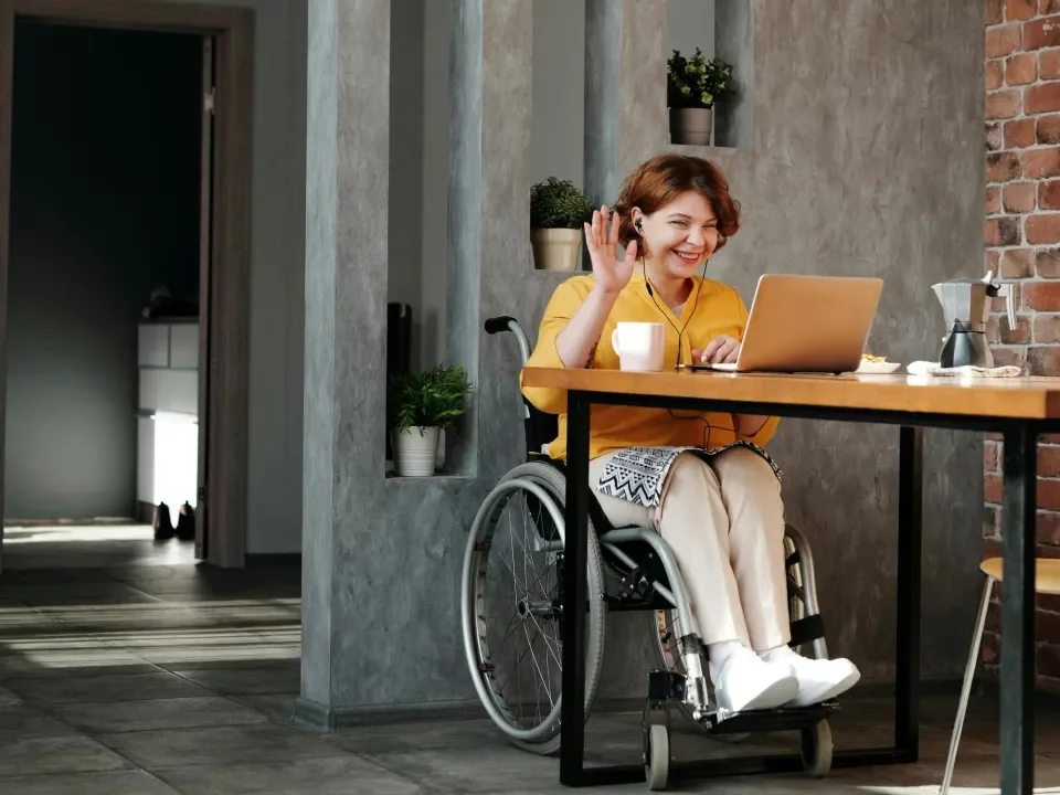 women in wheelchair on laptop at table