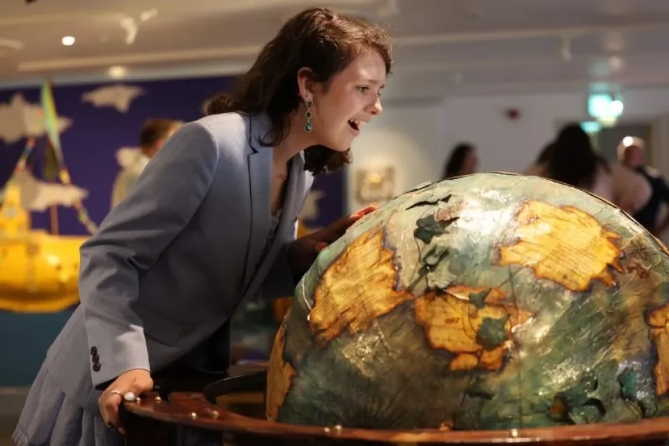 Woman looks at large globe art piece