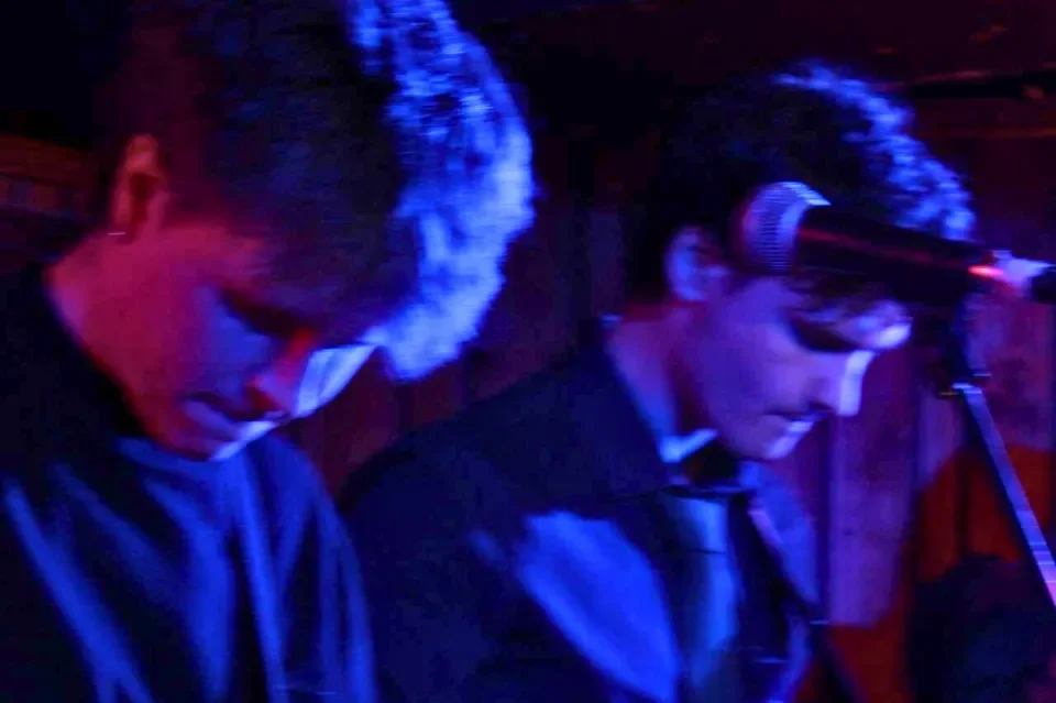 Moody lighting picture of two men playing guitar