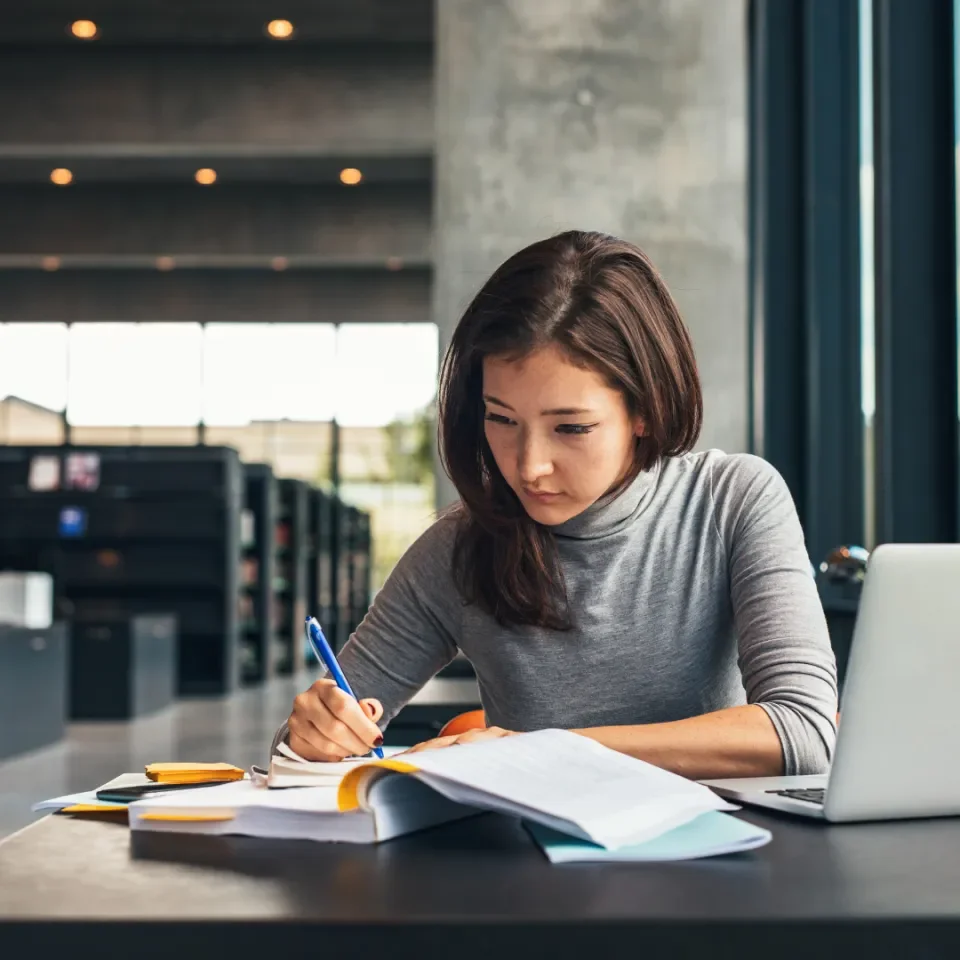 woman sitting at desk in library working off books