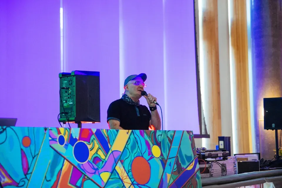 DJ Donal Dineen standing behind DJ decks which are decorated with bright colours