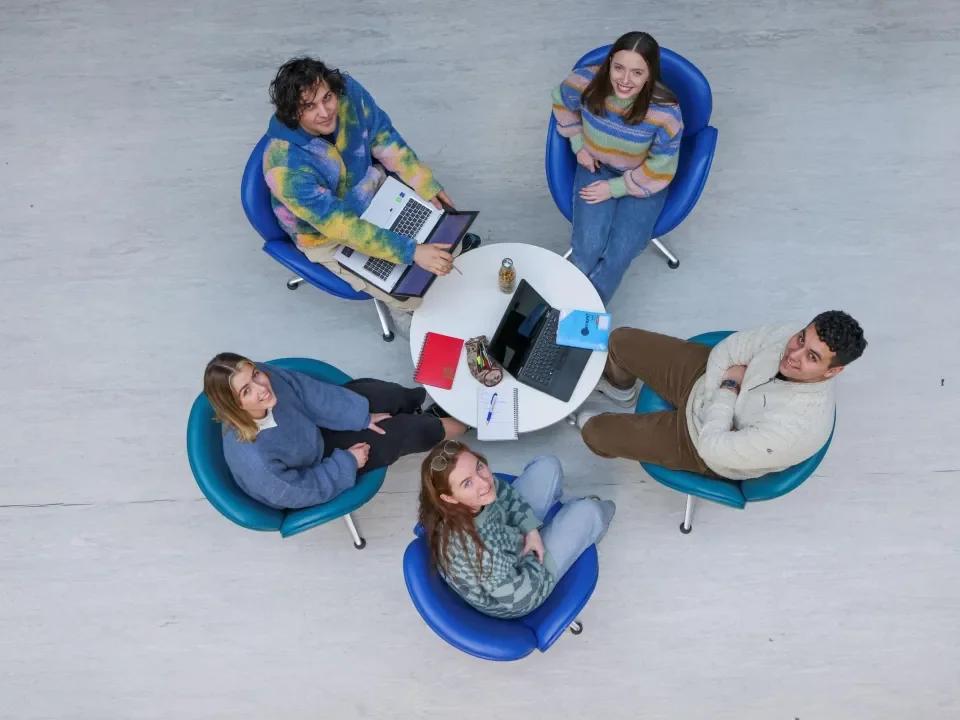 Students sitting down looking up at camera