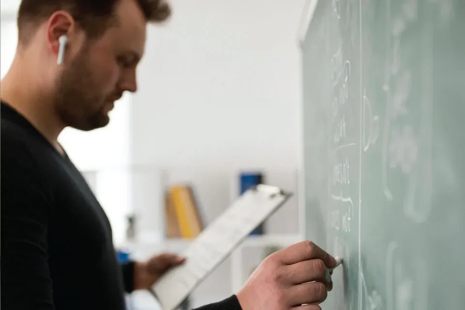 a teacher writing on the board in a class