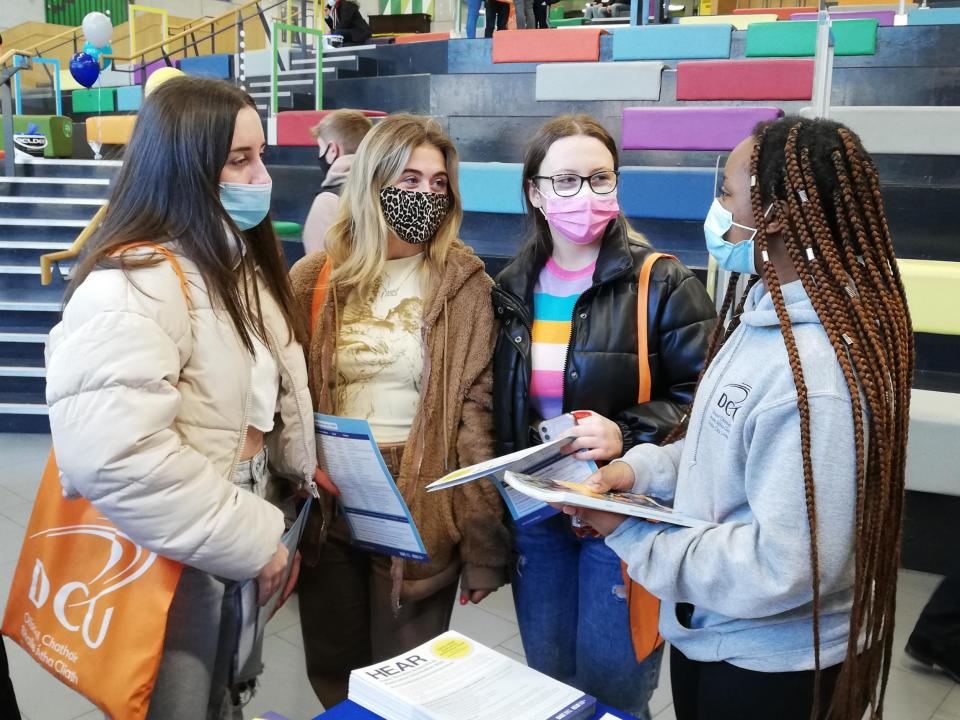 Female Student ambassador talking to three female students at DCU Open day