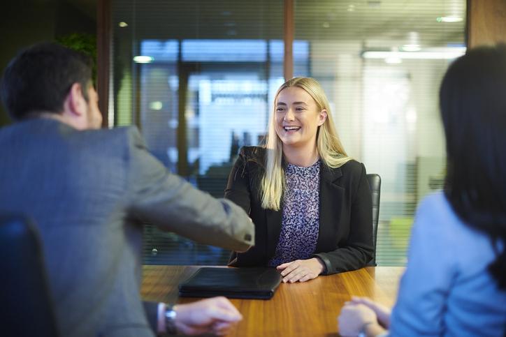 Smiling graduate shaking hands at interview