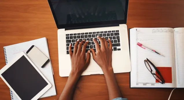 Hands typing on a laptop