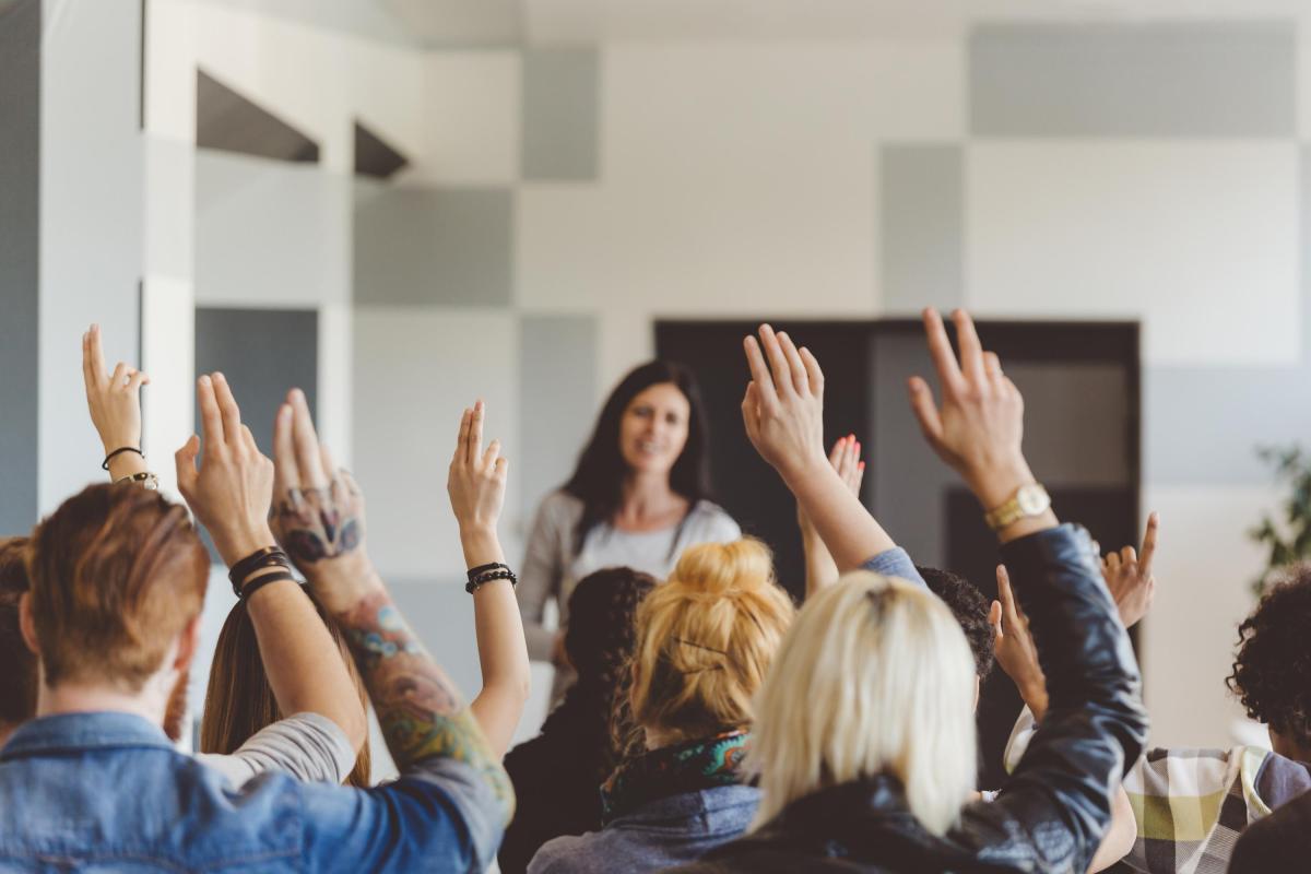 People raising hands during a seminar