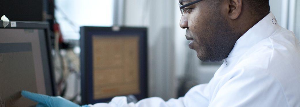 Man in lab coat at screen