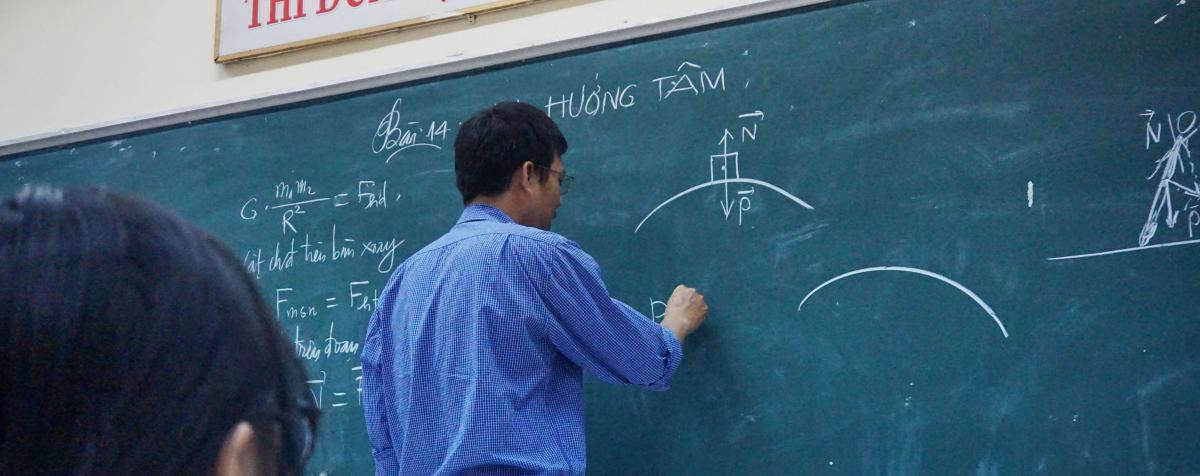 Man writing on blackboard