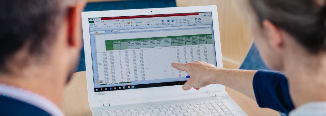 Man and woman looking at spreadsheet on computer screen