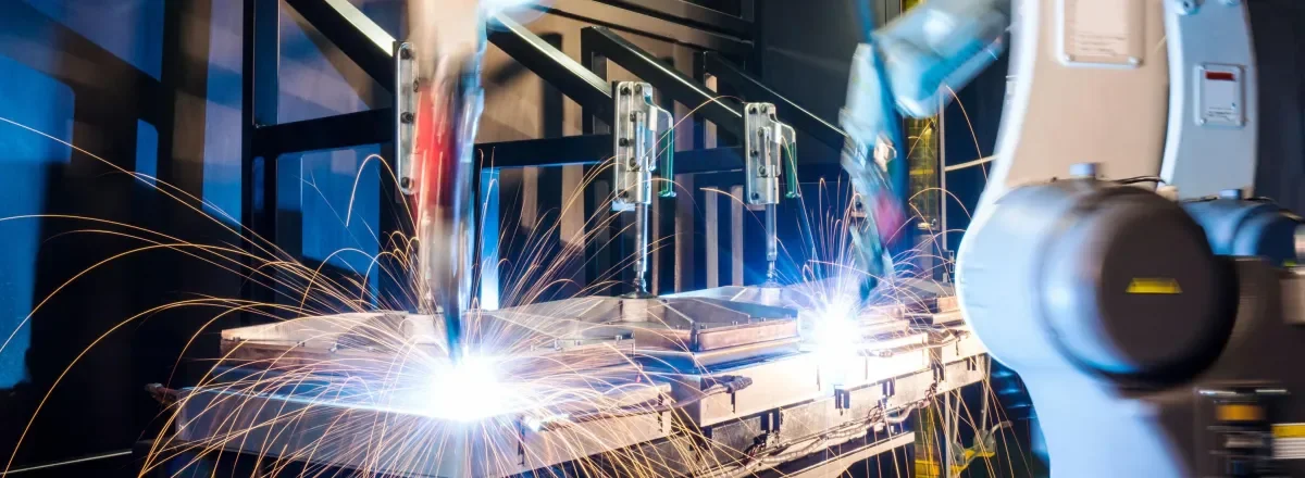 Shows robot arms doing some manufacturing