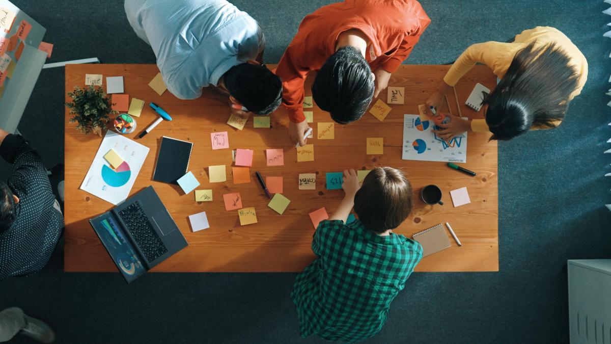 People around a table brainstorming and taking notes