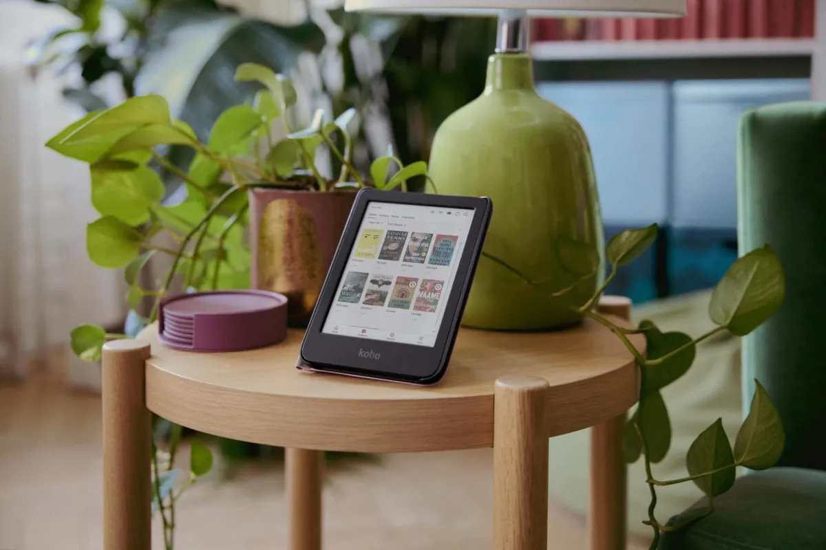 Photo of an eReader/tablet on a table surrounded by plants and other household items.