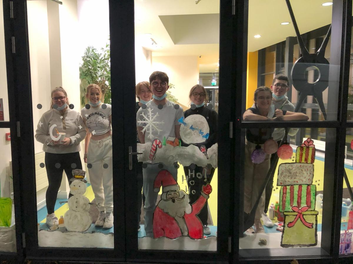 Mark Dunne with DCU RAG members standing in front of a glass door